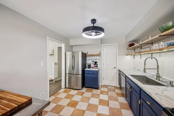 a kitchen with stainless steel appliances granite countertop a sink and a refrigerator