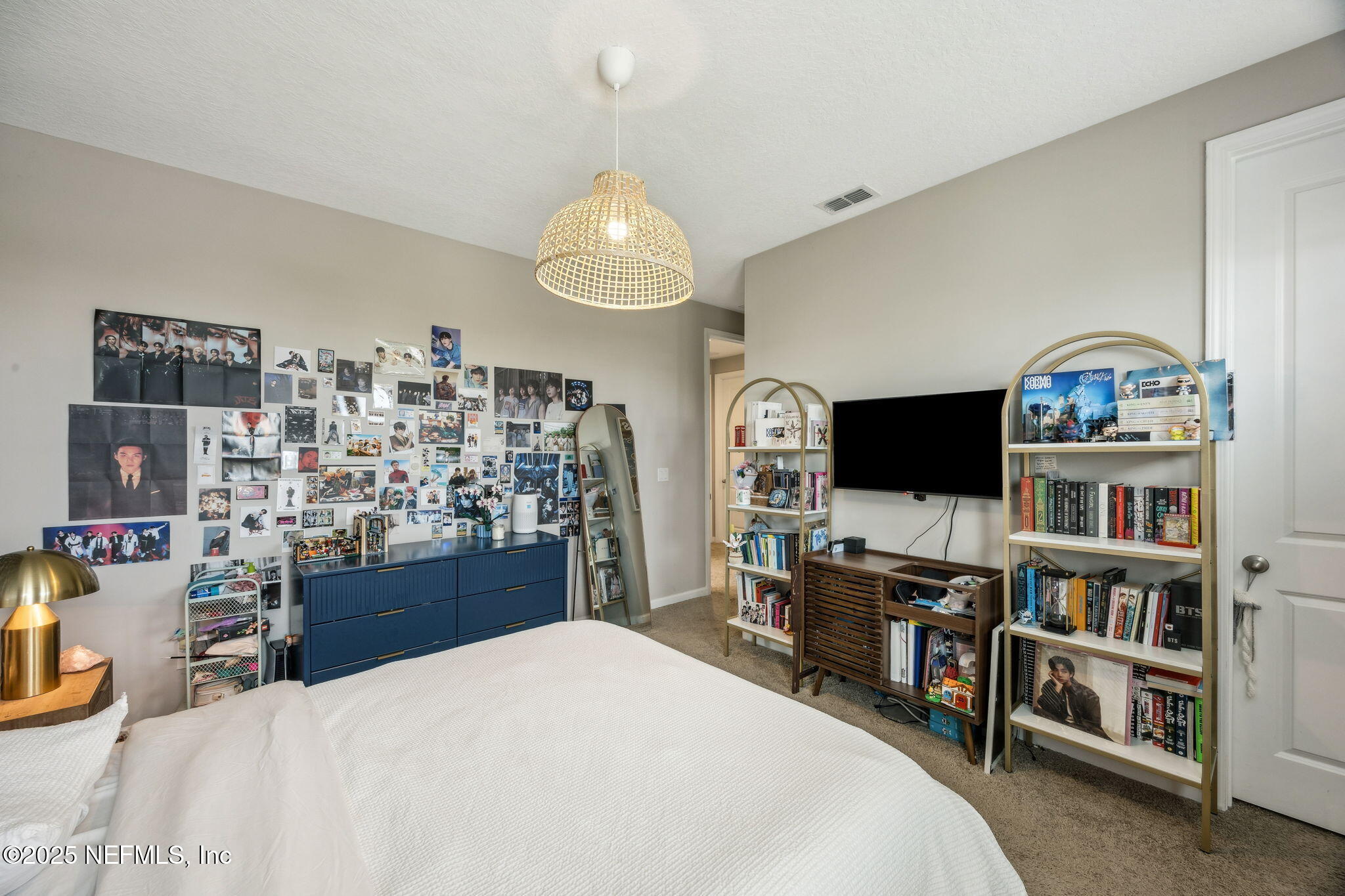 290 Rum Runner Way St. Johns, FL 32259 - Photo 35 of 105 a bedroom with a bed a flat screen tv and a book shelf