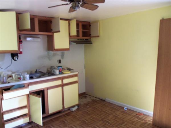 1032 Stafford Road Fall River, MA 02721 - Photo 3 of 5 a kitchen with stainless steel appliances a sink cabinets and a wooden floor