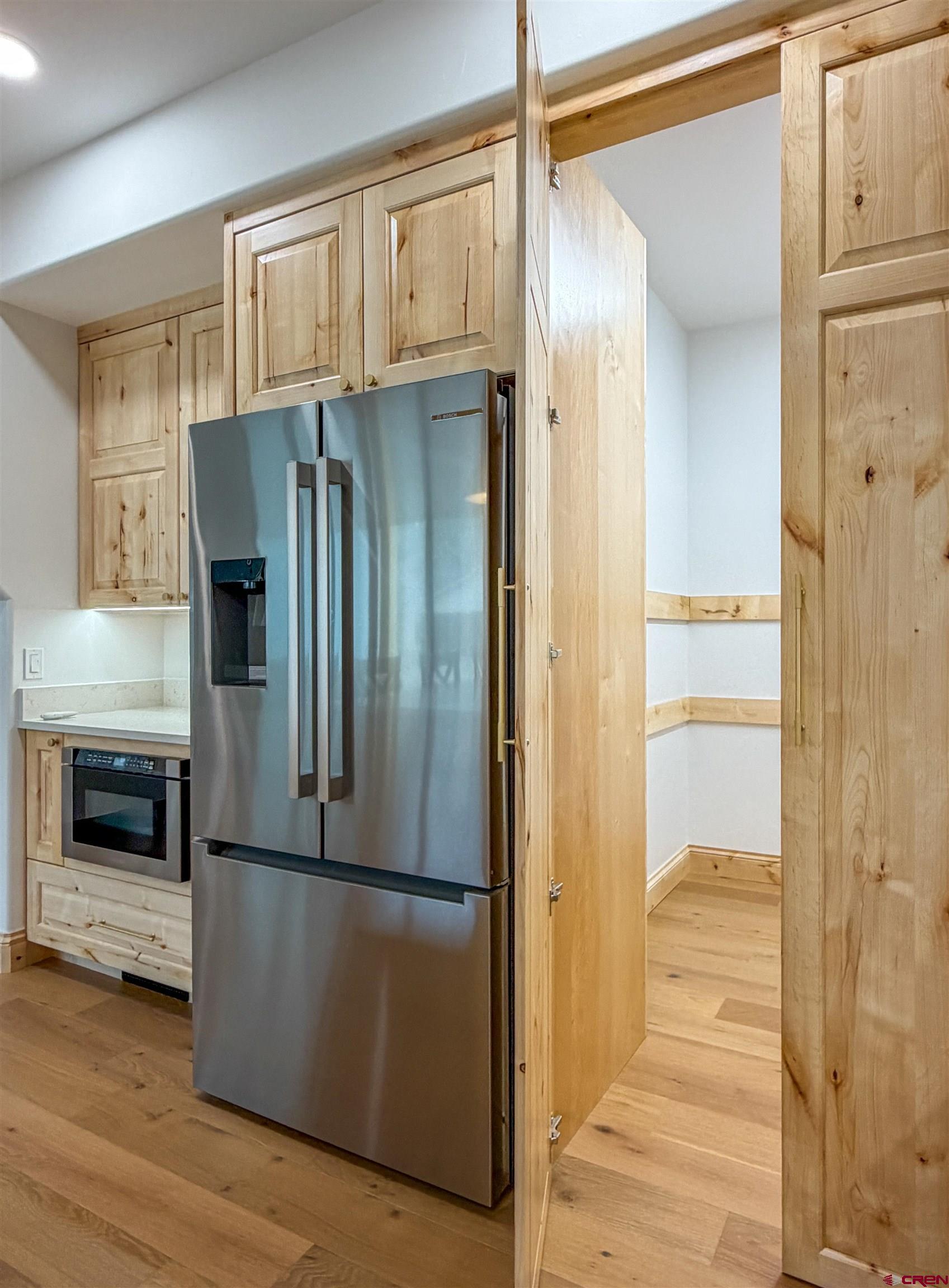 805 Southeast Pinyon Street Cedaredge, CO 81413 - Photo 18 of 45 a kitchen with a refrigerator and a wooden floor