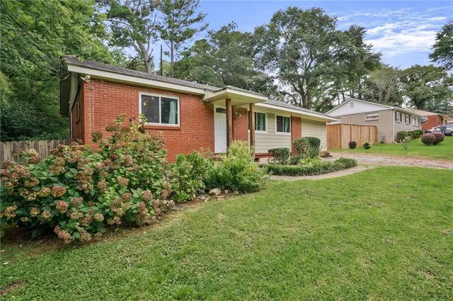a view of a yard in front of a house with large trees