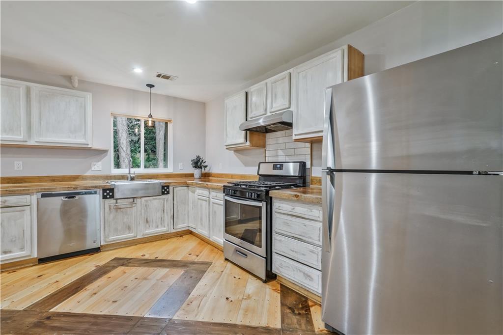 3225 Spring Drive Northwest Atlanta, GA 30360 - Photo 12 of 28 a kitchen with stainless steel appliances granite countertop a refrigerator sink and white cabinets