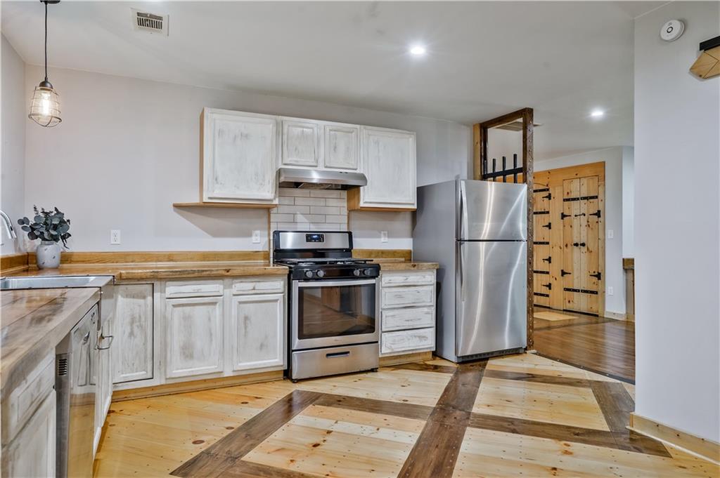 3225 Spring Drive Northwest Atlanta, GA 30360 - Photo 15 of 28 a kitchen with granite countertop a refrigerator and a stove top oven
