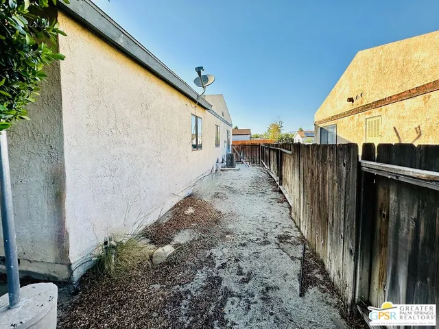 a view of a pathway of a house with wooden fence