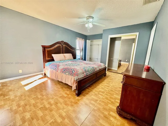 a spacious bedroom with a bed and a dresser