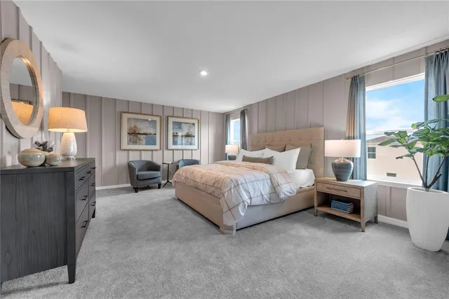 a spacious bedroom with a bed a mirror and a large window