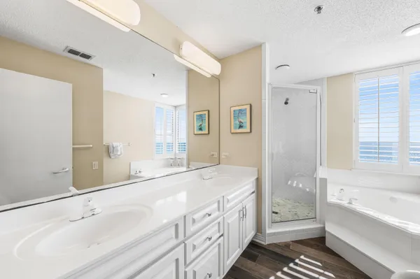 a spacious bathroom with a double vanity sink a mirror and a bathtub