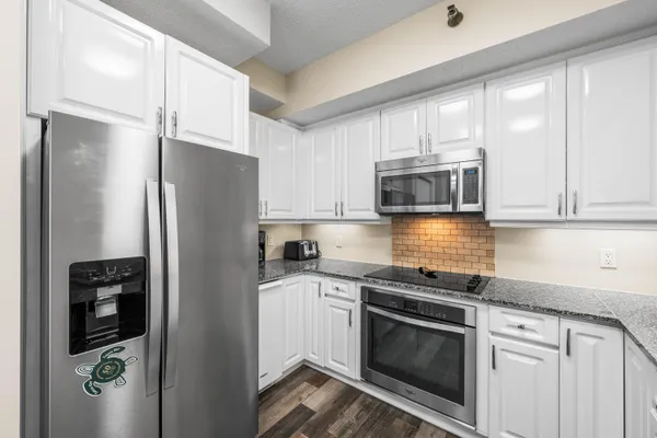 a kitchen with stainless steel appliances granite countertop a refrigerator stove and microwave