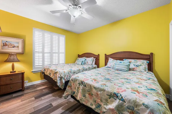a bedroom with two beds and painting on the wall