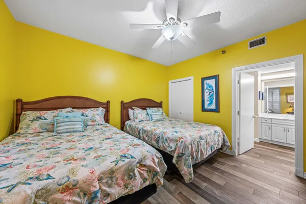a bedroom with 2 bed and wooden floor