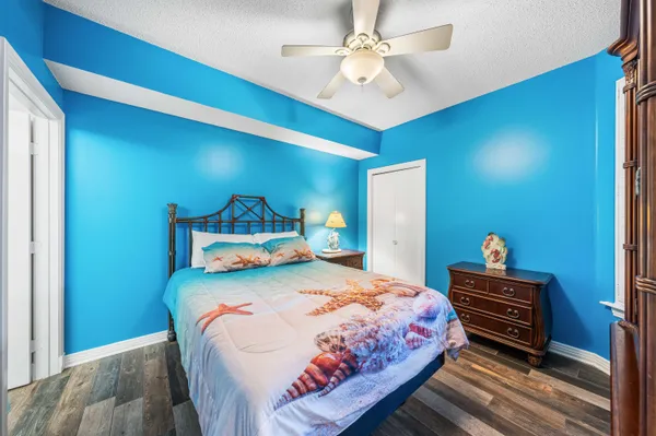 a bedroom with a bed a dresser and potted plant