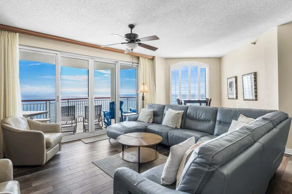 a living room with furniture a ceiling fan a fireplace and a large window