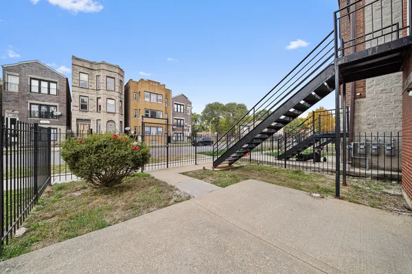 a view of a big building with a big yard and large trees