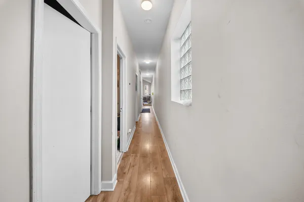 a view of a hallway with wooden floor