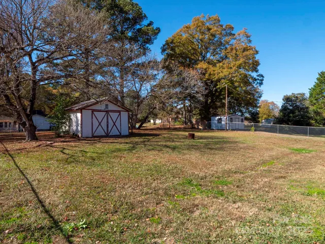 a view of a yard with large trees