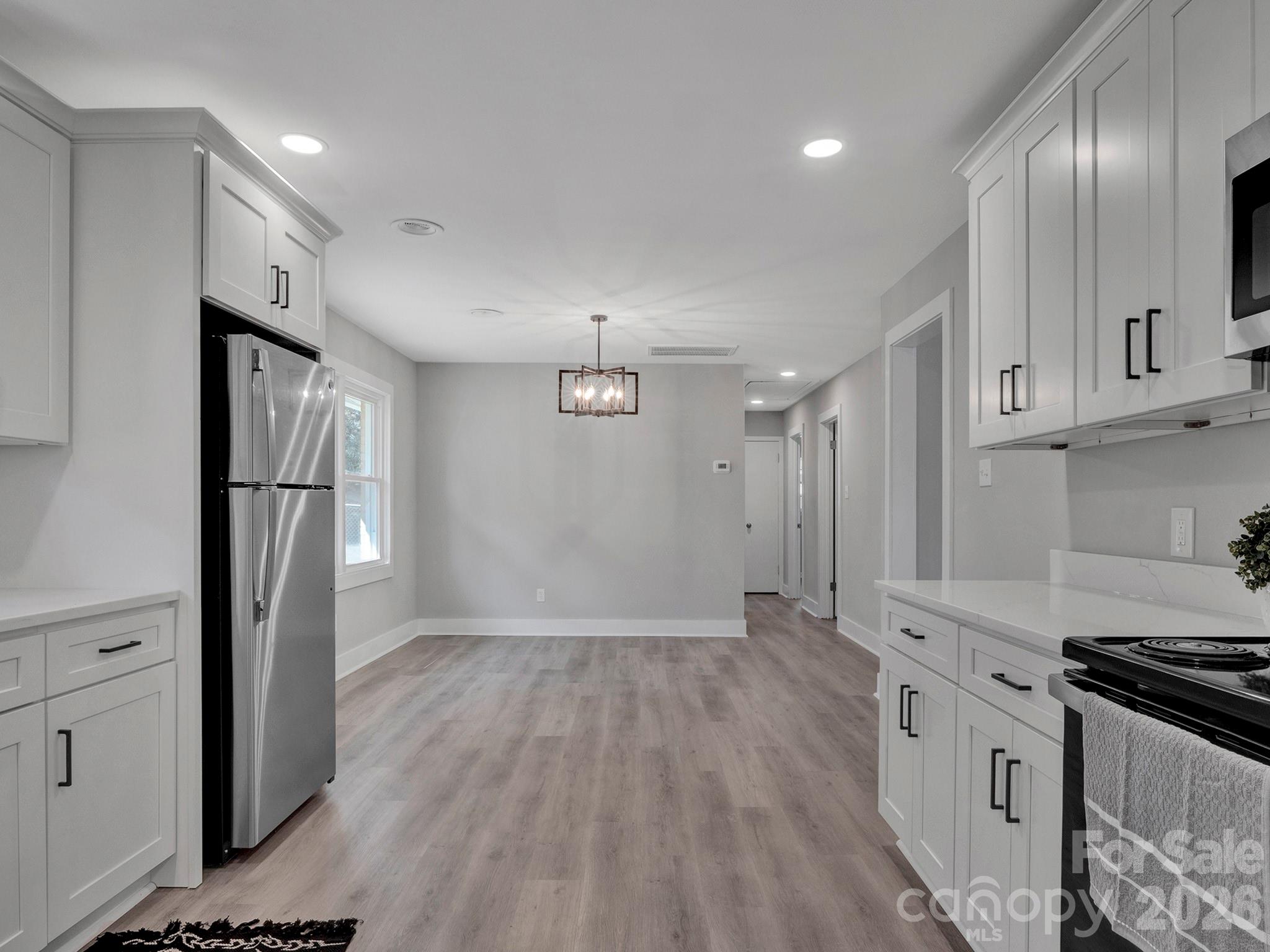 2826 State Rd S-29-656 Lancaster, SC 29720 - Photo 4 of 31 a kitchen with stainless steel appliances granite countertop a refrigerator a stove and white cabinets with wooden floors
