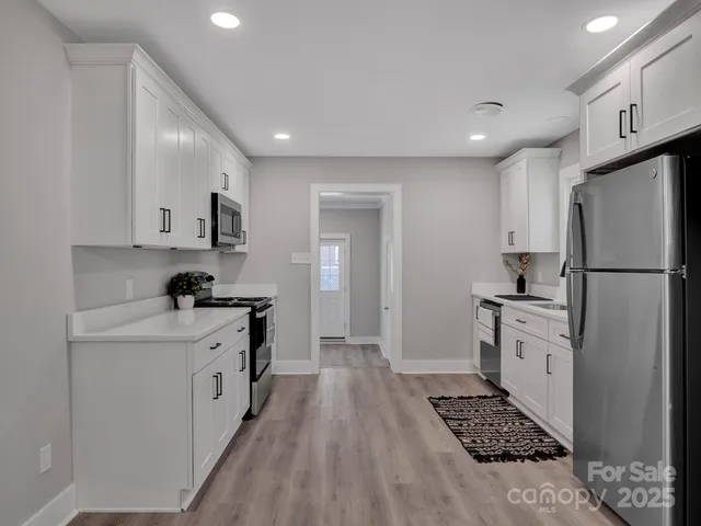 a kitchen with white cabinets and appliances