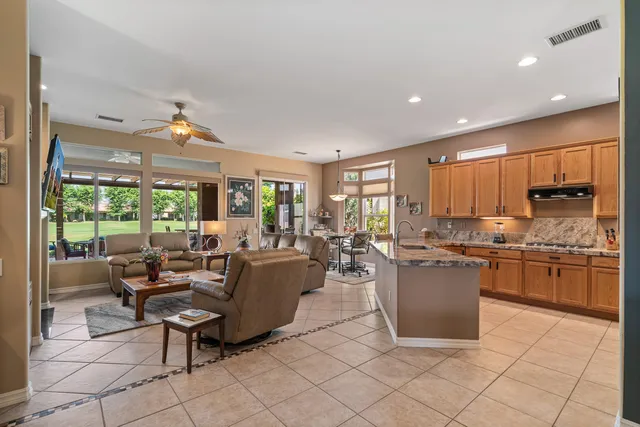 a living room with furniture a flat screen tv and large windows