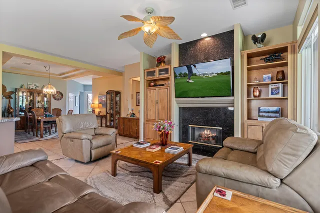 a living room with furniture a fireplace and a flat screen tv