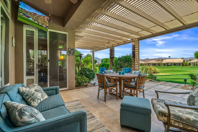 a view of a chairs and table in patio with a yard