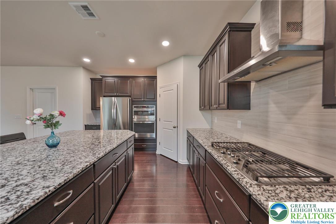 338 Abby Road Macungie, PA 18062 - Photo 12 of 40 a kitchen with stainless steel appliances granite countertop a sink stove and refrigerator