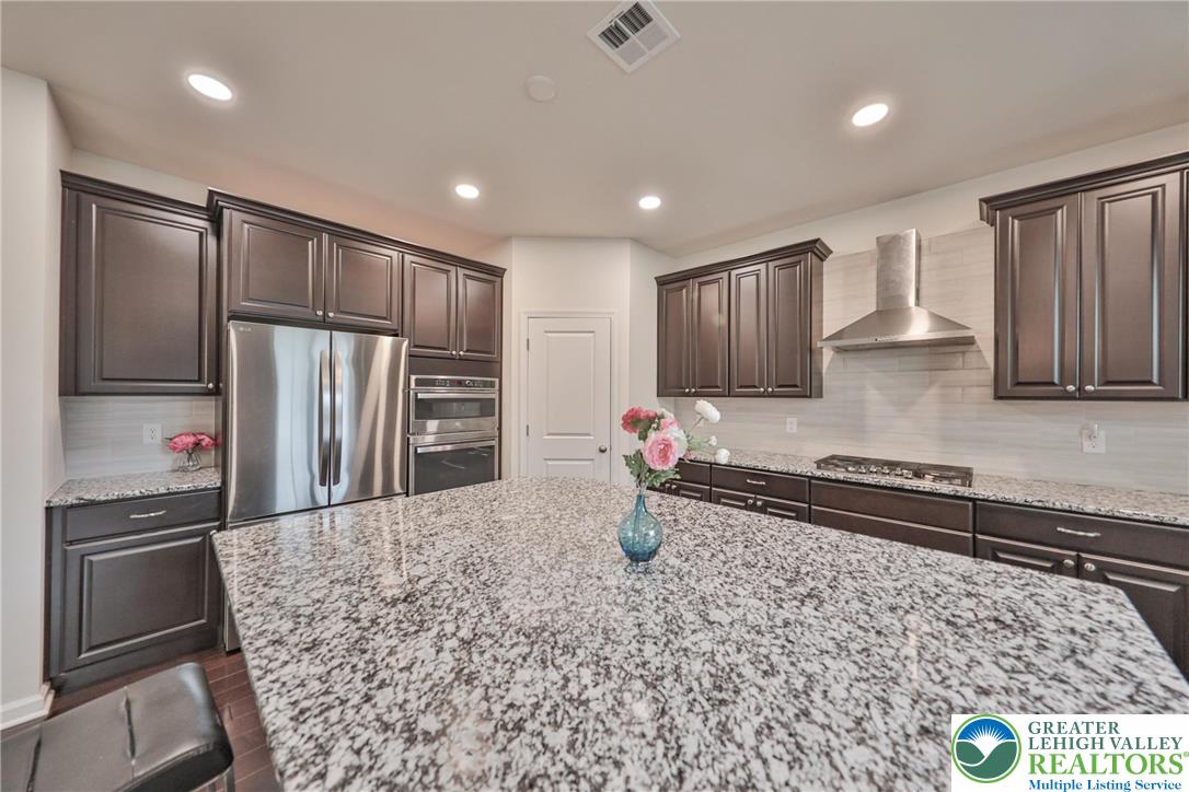 338 Abby Road Macungie, PA 18062 - Photo 13 of 40 a kitchen with stainless steel appliances granite countertop a refrigerator and a stove top oven