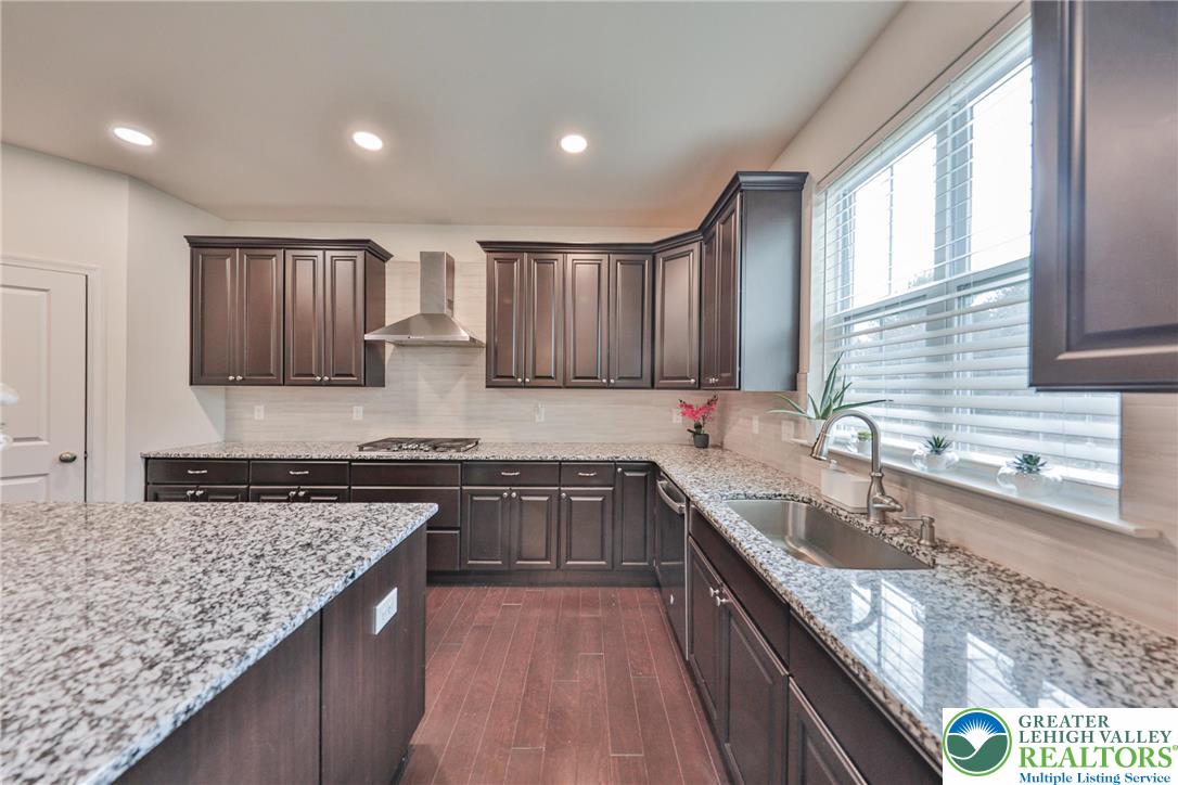 338 Abby Road Macungie, PA 18062 - Photo 15 of 40 a kitchen with stainless steel appliances granite countertop wooden cabinets a sink dishwasher a stove and a granite counter top