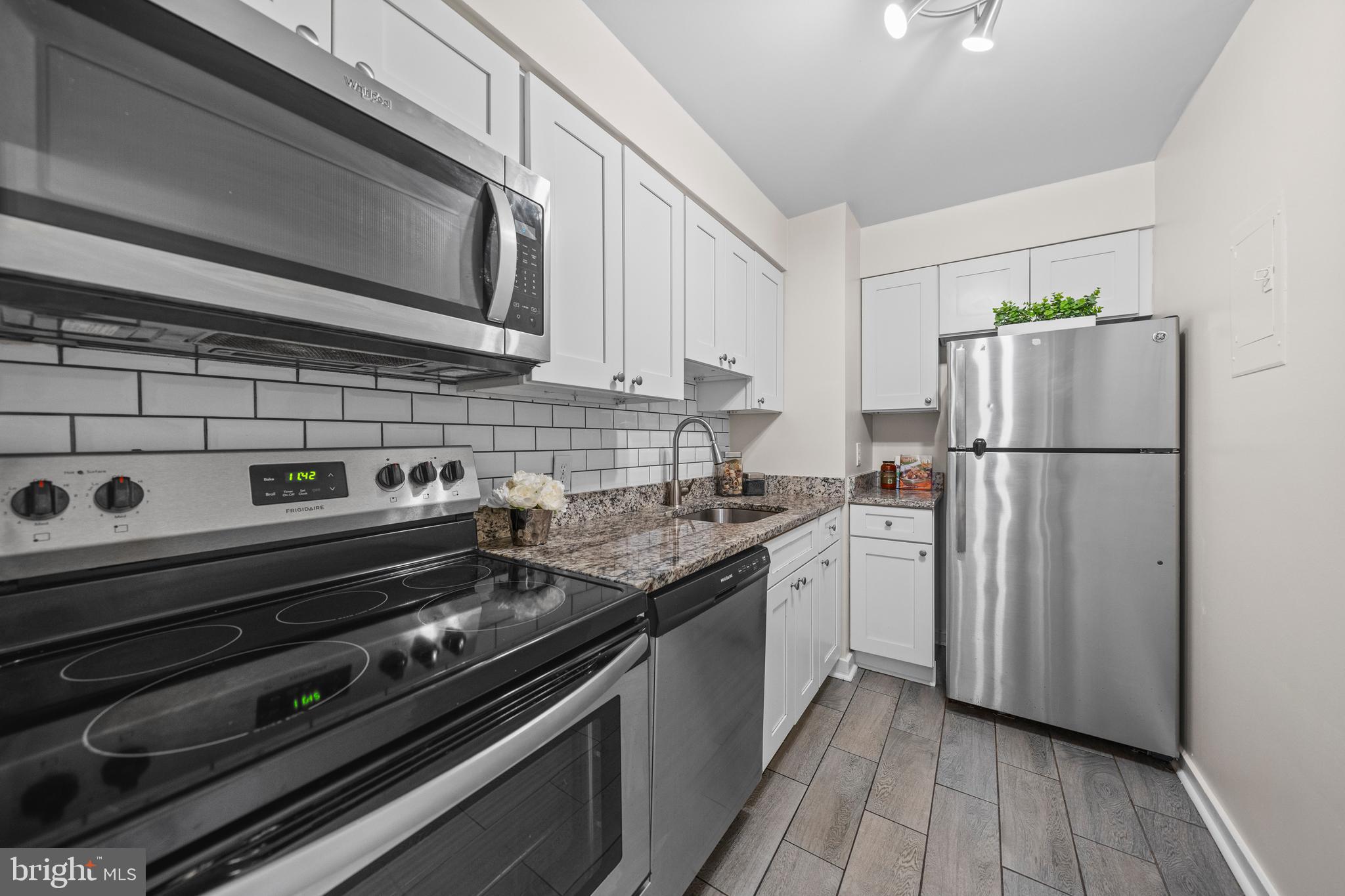 2214 Washington Avenue, Unit 204 Silver Spring, MD 20910 - Photo 9 of 32 a kitchen with a refrigerator stove and white cabinets