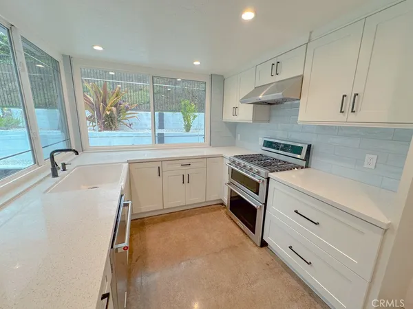 a kitchen with granite countertop white cabinets and white appliances