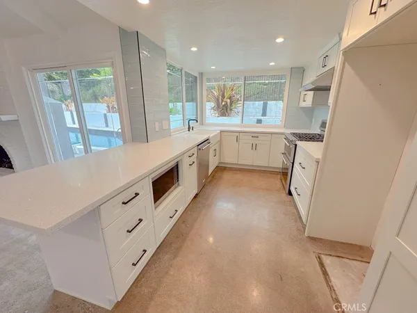 a kitchen with stainless steel appliances a sink and a large window