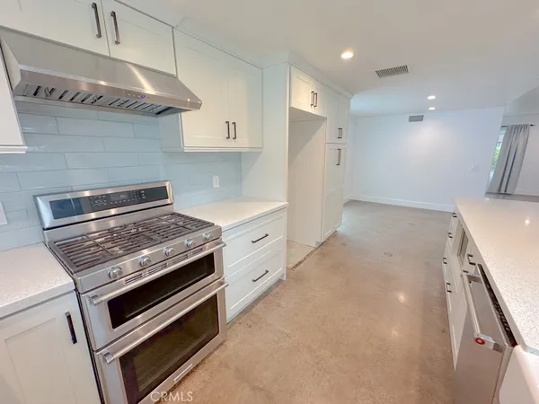 a kitchen with stainless steel appliances granite countertop a stove and a refrigerator