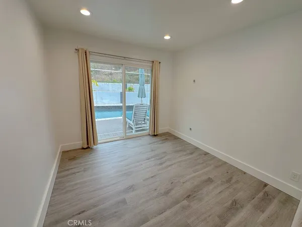 an empty room with wooden floor and window