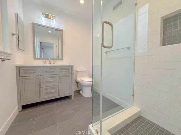 a bathroom with a granite countertop sink toilet and shower