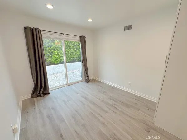 an empty room with wooden floor and a window