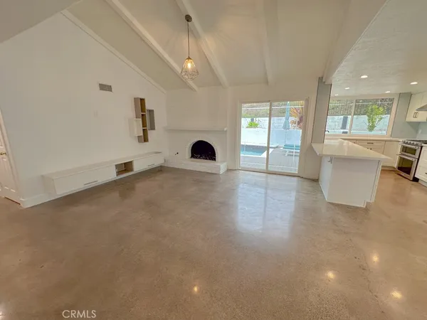 an empty room with fireplace and windows