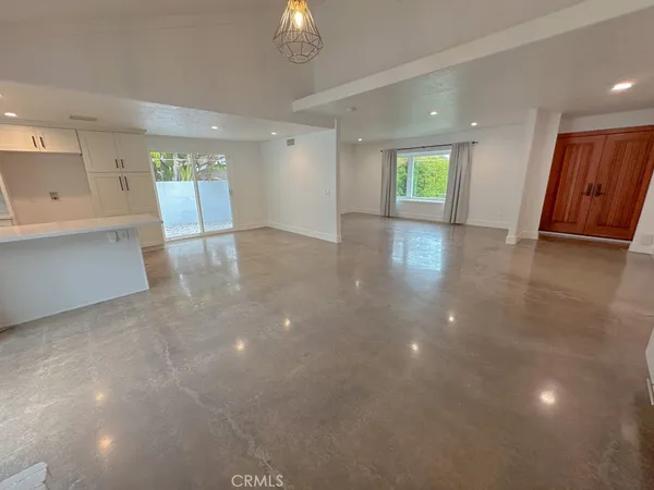a view of an empty room with a window and fireplace