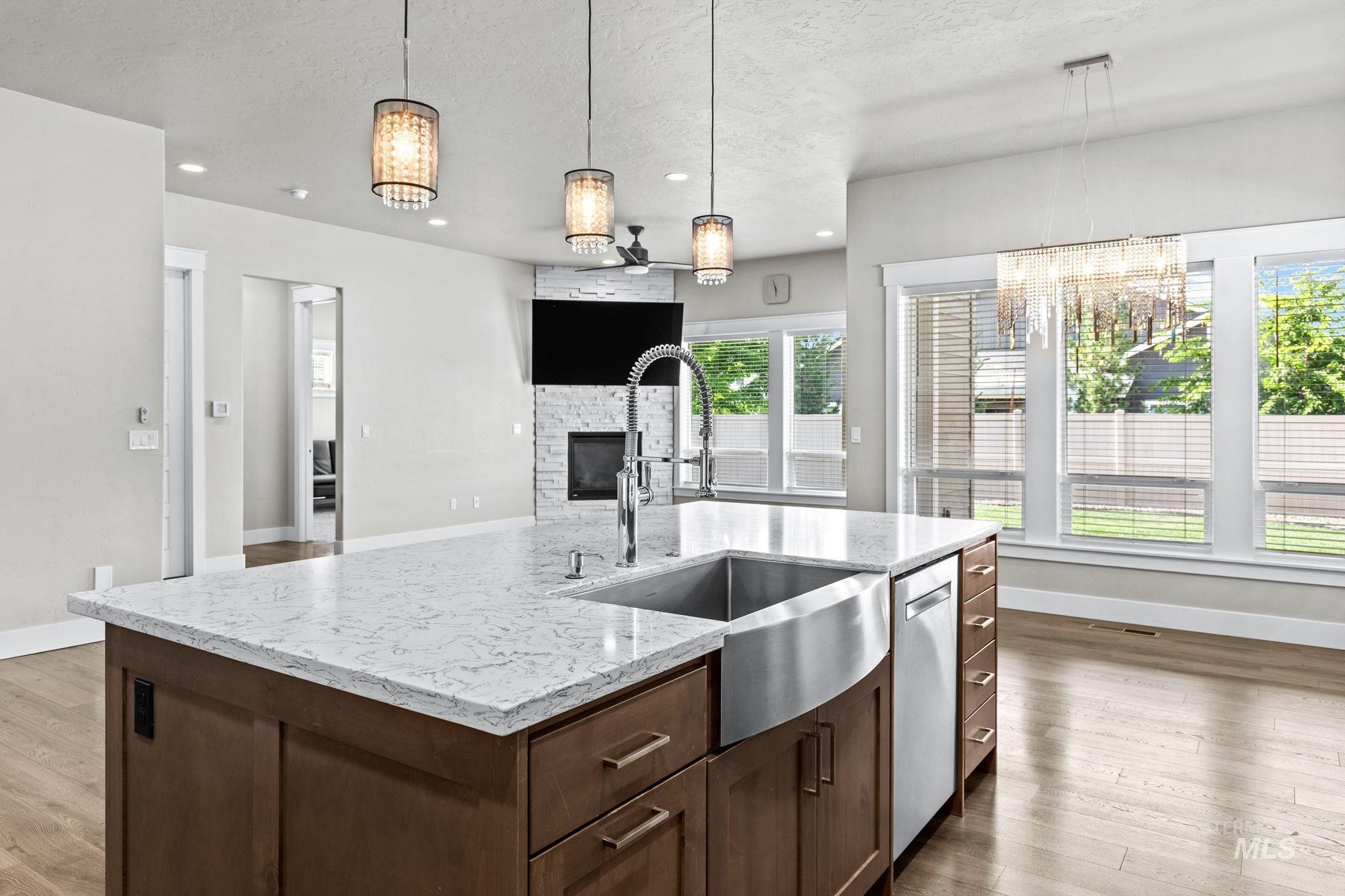 2934 East Murchison Street Meridian, ID 83642 - Photo 13 of 44 Kitchen island featuring a stainless steel farmhouse sink, gooseneck faucet, and integrated dishwasher