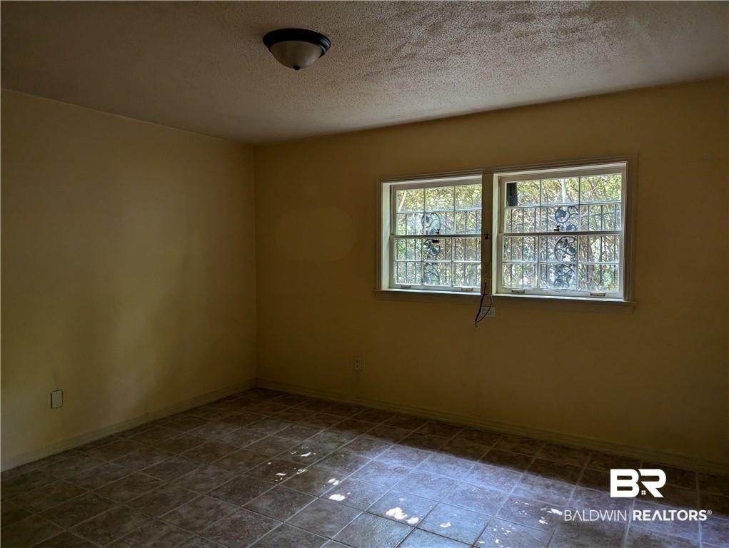 3608 Linden Lane Mobile, AL 36608 - Photo 6 of 20 Tiled empty room featuring a textured ceiling