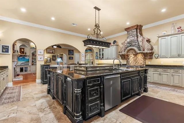 a kitchen with stainless steel appliances granite countertop a stove oven a dining table and chairs with wooden floor