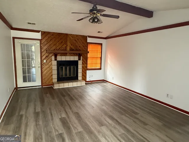 a view of an empty room with a fireplace and a window
