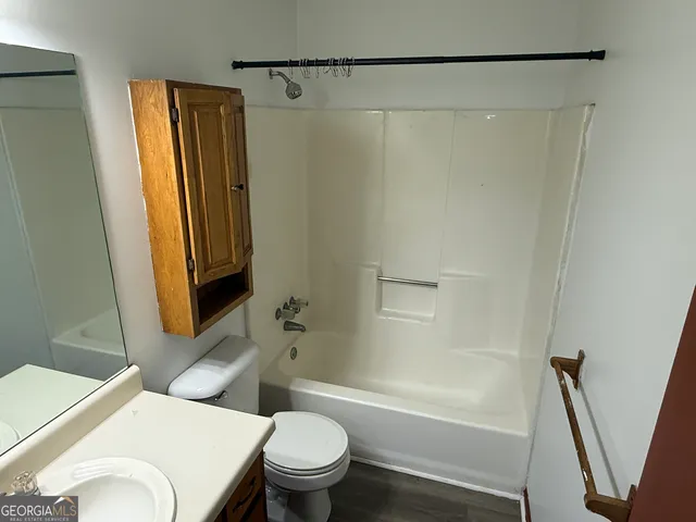 a white toilet sitting next to a bath tub