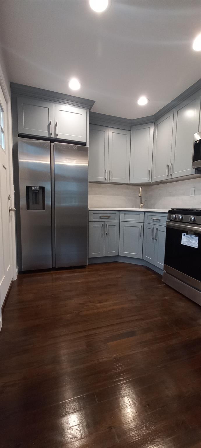 3 Hampton Road Lynbrook, NY 11563 - Photo 15 of 23 Kitchen featuring stainless steel appliances, dark wood-style floors, backsplash, and gray cabinets