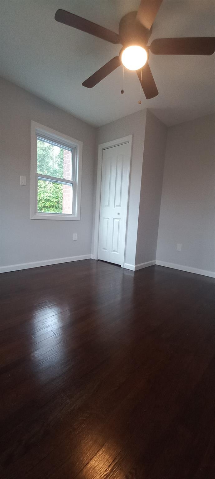 3 Hampton Road Lynbrook, NY 11563 - Photo 18 of 23 Empty room with ceiling fan, dark wood-style flooring, and baseboards