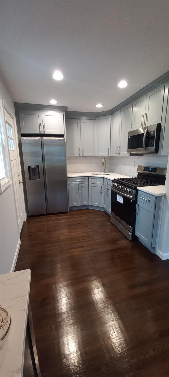 3 Hampton Road Lynbrook, NY 11563 - Photo 2 of 23 Kitchen with a sink, light countertops, appliances with stainless steel finishes, and dark wood-style floors