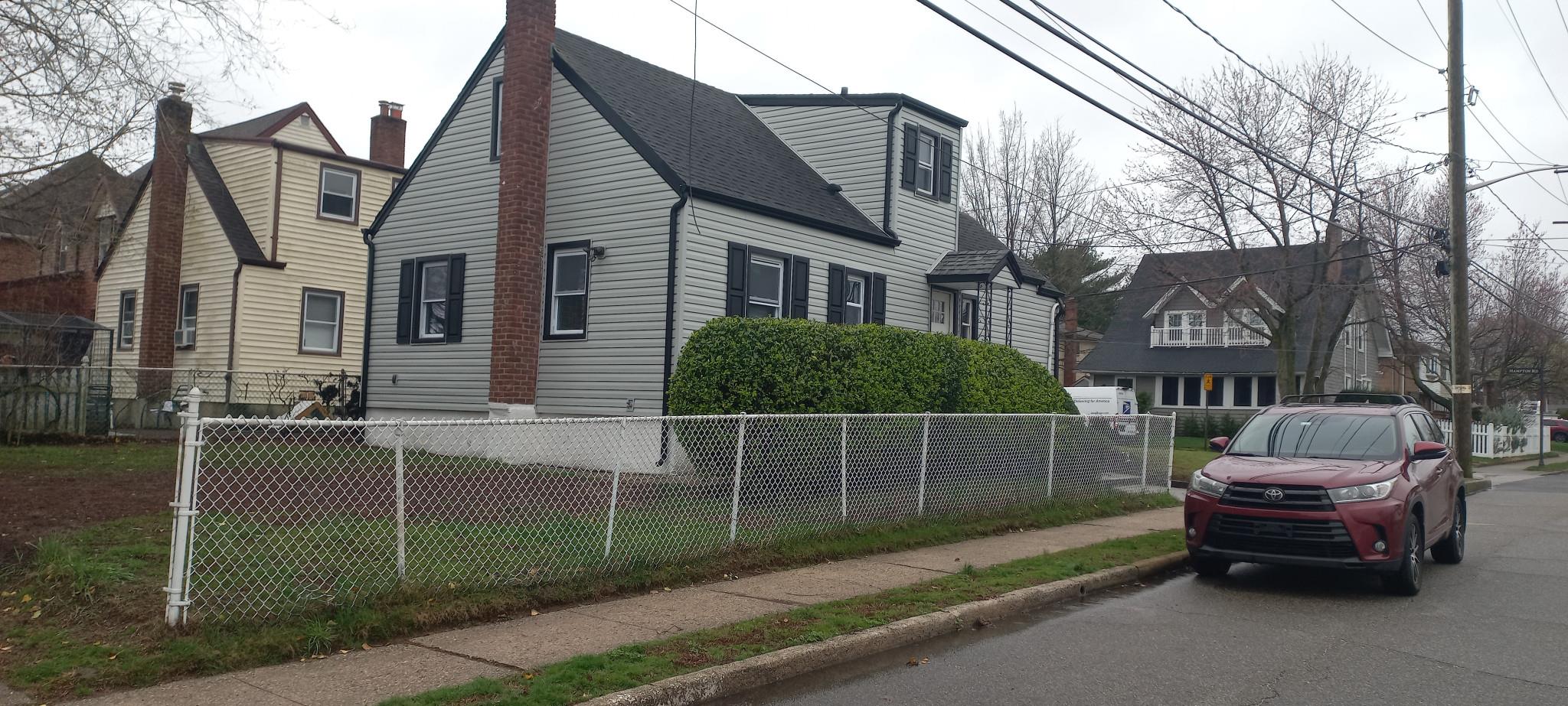 3 Hampton Road Lynbrook, NY 11563 - Photo 3 of 23 View of side of property featuring roof with shingles, a chimney, and a fenced front yard