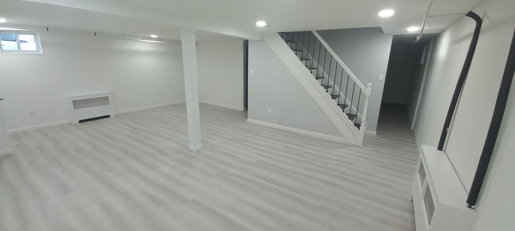 3 Hampton Road Lynbrook, NY 11563 - Photo 5 of 23 Below grade area with baseboards, recessed lighting, stairway, light wood-style flooring, and radiator