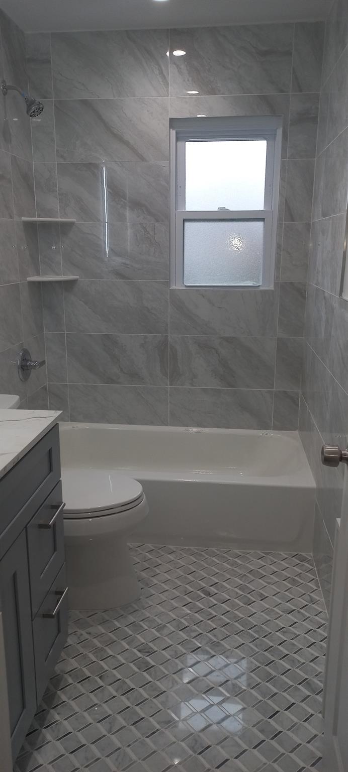 3 Hampton Road Lynbrook, NY 11563 - Photo 6 of 23 Bathroom featuring tile patterned flooring, vanity, toilet, and shower / washtub combination