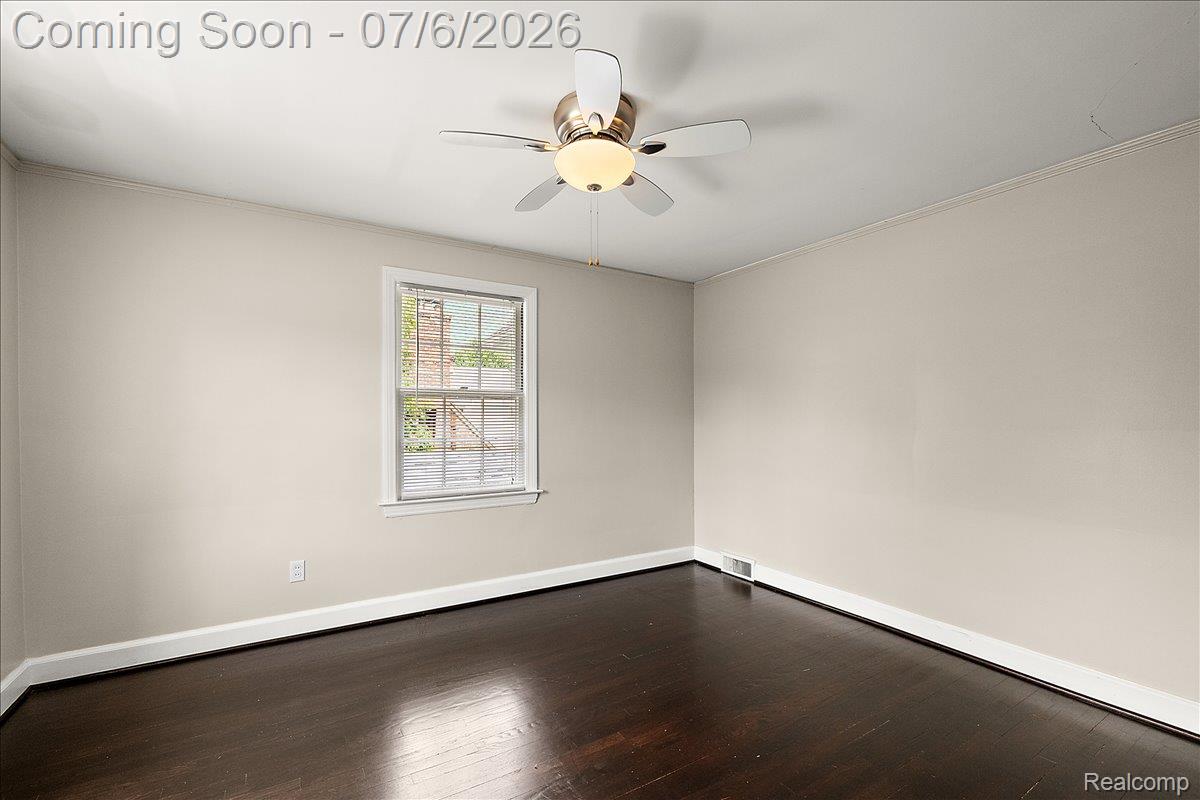 1051 Devonshire Road Grosse Pointe, MI 48230 - Photo 57 of 98 Room featuring a ceiling fan with integrated lighting, a double-hung window with white trim, dark wood-finish flooring, and white baseboards