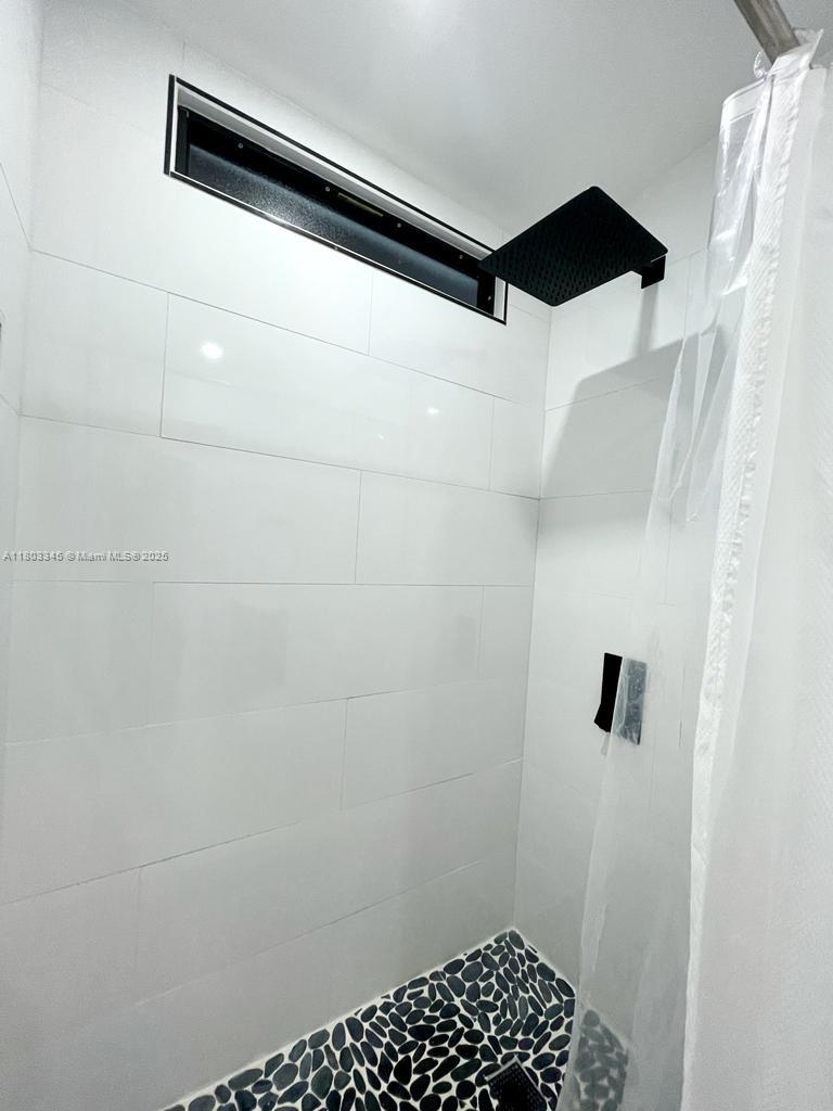 271 Lance Lane Key Largo, FL 33037 - Photo 29 of 33 a bathroom with a shower and a tiled wall