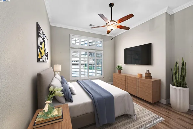 a bedroom with a bed a window and a flat screen tv